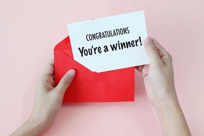 Hands holding a congratulations card and a red envelope