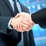SHOCKING Move — Trump Media Announces MONSTER MERGER Two business professionals shaking hands in a corporate setting