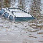 Flood SURGE Looms: 30M Under WATCH A partially submerged vehicle in floodwaters