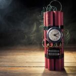A stick of dynamite with a clock timer and wires, set against a dark smoky background