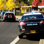 Bus Aide ASSAULTS Autistic Kids–How This HAPPENED Police cars and school buses on a road.