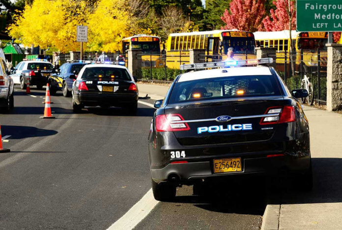 117302929 Police cars and school buses on a road.