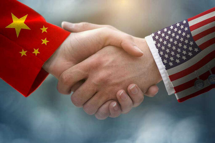 Chinese and American flag sleeves shaking hands.