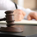 TRUMP Authority DERAILED by Judge’s Ruling Judges gavel on desk with person writing.