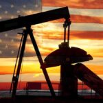 Oil TAKEOVER Begins–What This Means to US Silhouette of an oil pump jack against a sunset background with an American flag overlay