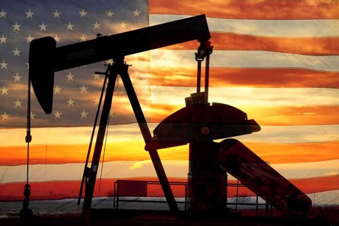shutterstock_131052803.jpg Silhouette of an oil pump jack against a sunset background with an American flag overlay