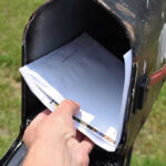 Democrats Built SECRET 50-Day Ballot Operation Hand placing mail in a black mailbox.