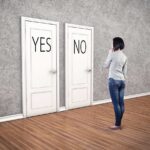 Veteran Cop AXED Over Restroom Drama A person standing in front of two doors labeled YES and NO
