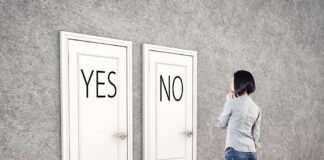 A person standing in front of two doors labeled YES and NO