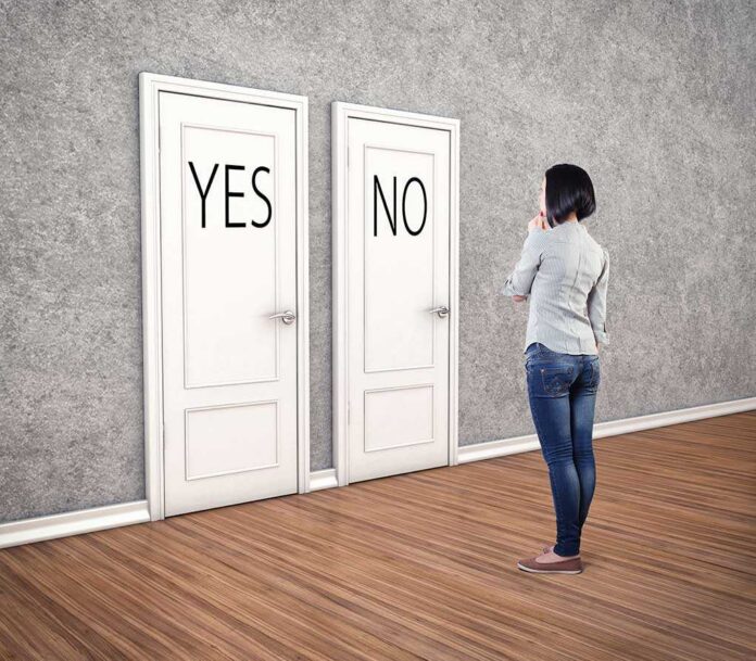 A person standing in front of two doors labeled YES and NO