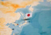 Japan ABANDONS Peace Pledge—Aims Weapons at China Map of Japan with flag pin placed nearby
