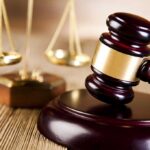 UNCONSTITUTIONAL Ruling Shatters D.C. Gun Ban A wooden gavel and scales of justice on a table
