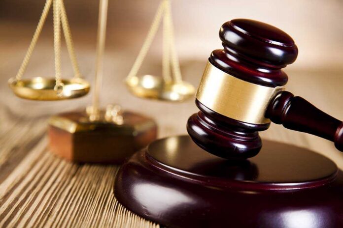 shutterstock_184689941.jpg A wooden gavel and scales of justice on a table