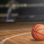 Anonymous Email DESTROYS Entire Basketball Program A basketball resting on a wooden court