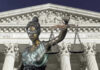 Lady Justice statue in front of courthouse.