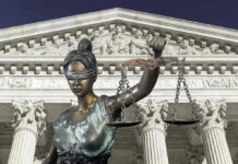 Lady Justice statue in front of courthouse.