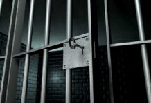 Trump Vows JAIL For Leaker Who Endangered Wounded Airman Close-up of a locked prison gate with metal bars