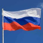 The flag of Russia waving against a clear blue sky