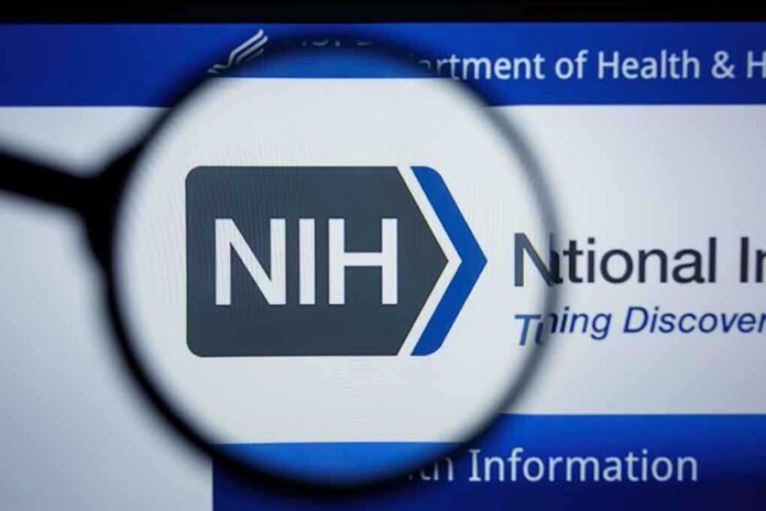 NIH logo displayed on a digital screen, viewed through a magnifying glass