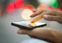 A person using a smartphone with a colorful bokeh background