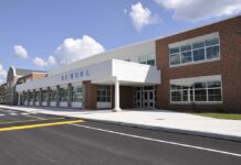 Modern school building with large windows and a clear sky