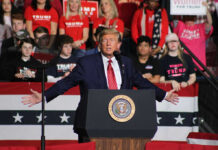 Trump ENDS Colbert And Has The Last Laugh Politician speaking at rally with supporters behind him.