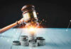 Gavel, coins, and tax icons on a table.