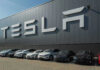 Tesla’s Promises BUSTED! CONSUMER Court Win! Tesla facility with parked cars in front.
