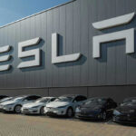 Tesla’s Promises BUSTED! CONSUMER Court Win! Tesla facility with parked cars in front.