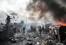 Russia’s Chilling Warning: Evacuate Kyiv NOW A chaotic protest scene with smoke, fire, and people holding flags