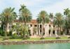 Billionaire’s $7.2M Regret: Shocking PAYOUT A luxurious mansion surrounded by palm trees and a waterfront view