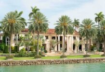 Billionaire’s $7.2M Regret: Shocking PAYOUT A luxurious mansion surrounded by palm trees and a waterfront view