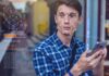 Facial Recognition SCANDAL: What Are They HIDING Young man using a smartphone with face recognition overlay
