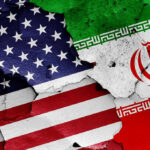 Before you believe it, check what’s signed. Cracked American and Iranian flags painted on a wall.