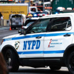 Rush-Hour Bloodbath Rocks Penn Station NYPD police car on a city street scene.