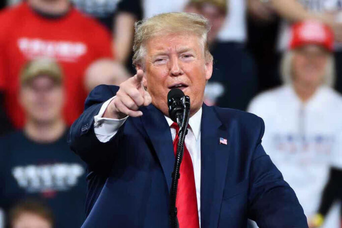 1585237510-1 Man in suit pointing, speaking at a rally.