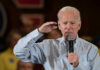 Man holding microphone making a gesture while speaking