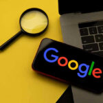 German Judge SLAPS Google Over AI Lies Magnifying glass, laptop, and smartphone displaying Googles logo.