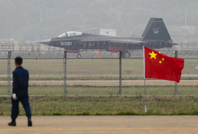 231381238 Jet with 31001 marking behind barbed wire fence.