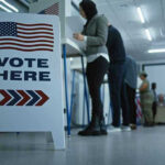 Grassroots Socialist Stuns Political Establishment in New York Sign reading Vote Here in a polling station.