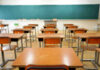 Empty classroom with desks and a chalkboard.