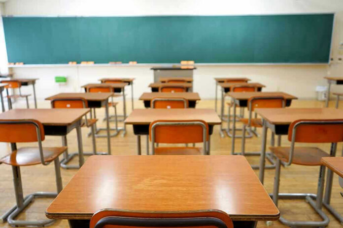356921618 Empty classroom with desks and a chalkboard.