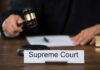 Supreme Court Case Could Redefine Birthright Citizenship Judge with gavel and Supreme Court nameplate.