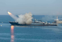 Iran Attack Kills Civilian, Disrupts Kuwait Airport Warship firing missile in the sea.