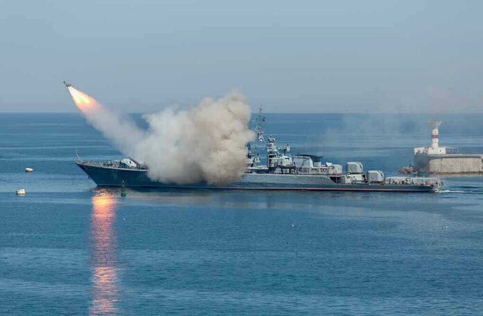 533229181 Warship firing missile in the sea.