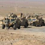 Beaufort Grab Sparks New Gaza Fears Soldiers beside military vehicles in a desert area.