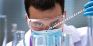 Scientist conducting an experiment with blue liquids in a laboratory