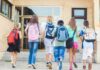 Federal Prosecutors Hit Alleged School Drug Ring With 21 Charges Group of children walking towards a school entrance with backpacks