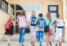 Federal Prosecutors Hit Alleged School Drug Ring With 21 Charges Group of children walking towards a school entrance with backpacks
