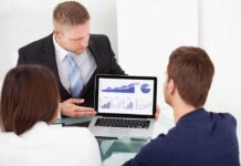 Anthropic Releases AI Model With Safeguards Business professional presenting data on a laptop to two colleagues